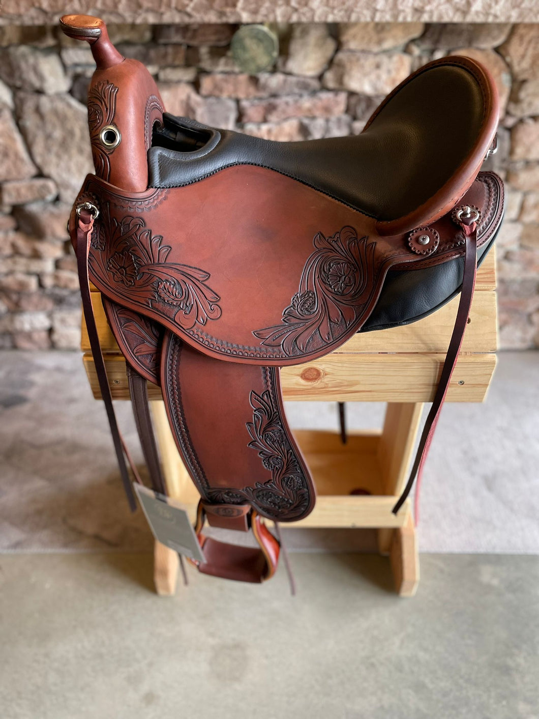 dp saddlery quantum short and light western with western dressage seat, side view on a wooden saddle rack