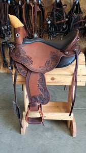 dp saddlery quantum short and light western with western dressage seat 6201, side view on a wooden saddle rack, horse tack in background