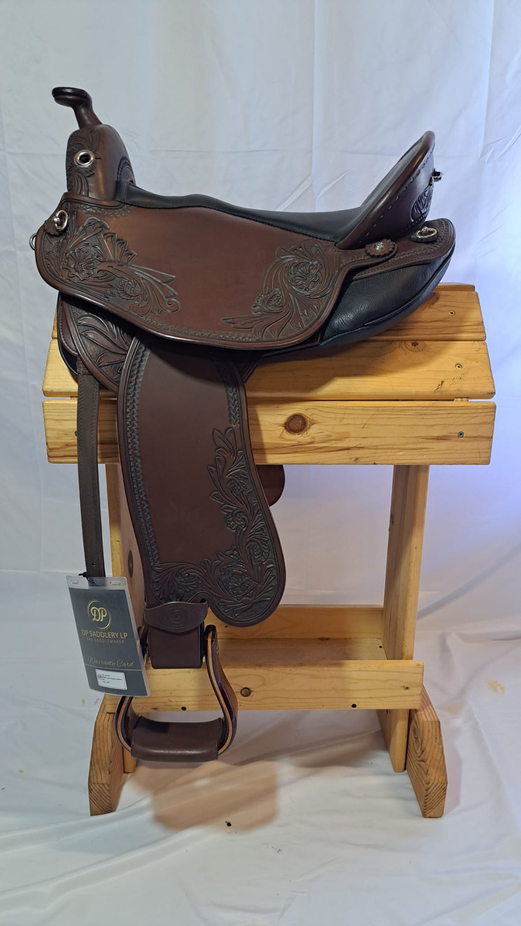 dp saddlery quantum short and light western with western dressage seat, side view on a wooden saddle rack, white background