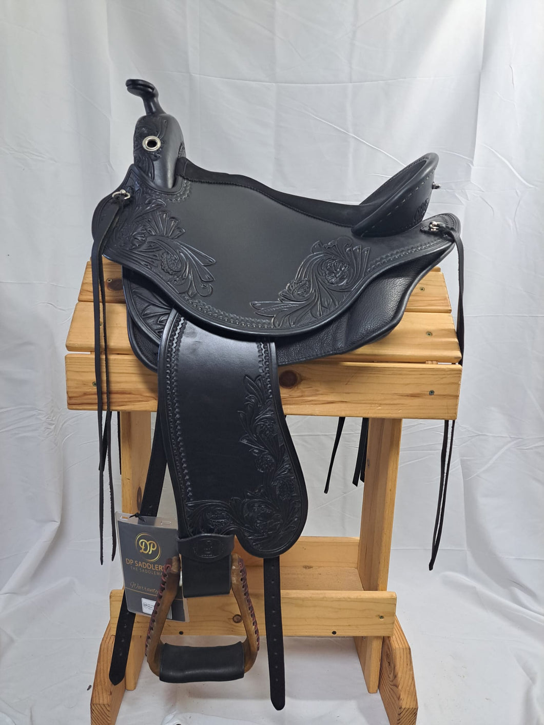 dp saddlery quantum western with western dressage seat 6634, side view on a wooden saddle rack, white background