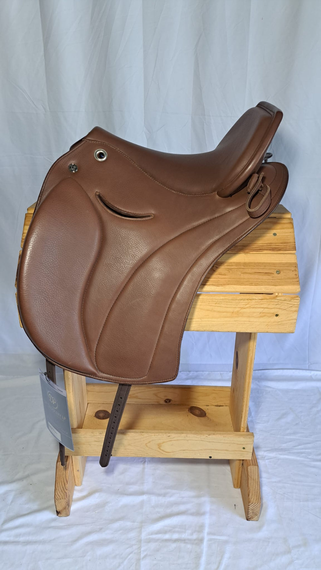 DP Saddlery Majestro 6940, side view on a wooden saddle rack, white background