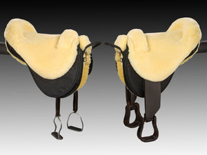 two christ cloud special plus fur saddles, natural color, side view, one has endurance stirrups and the other has standard stirrups, black background
