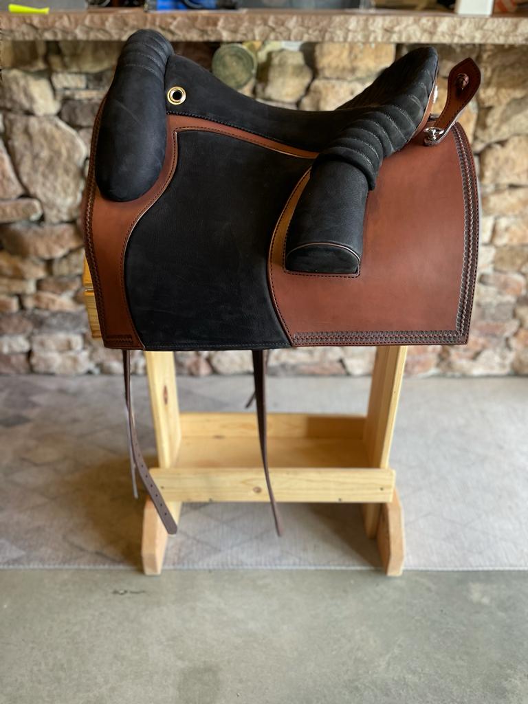 dp saddlery bueckeburger schooling saddle, side view on wooden saddle rack