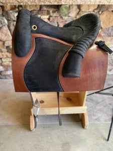 Side view of saddle on wooden saddle rack 