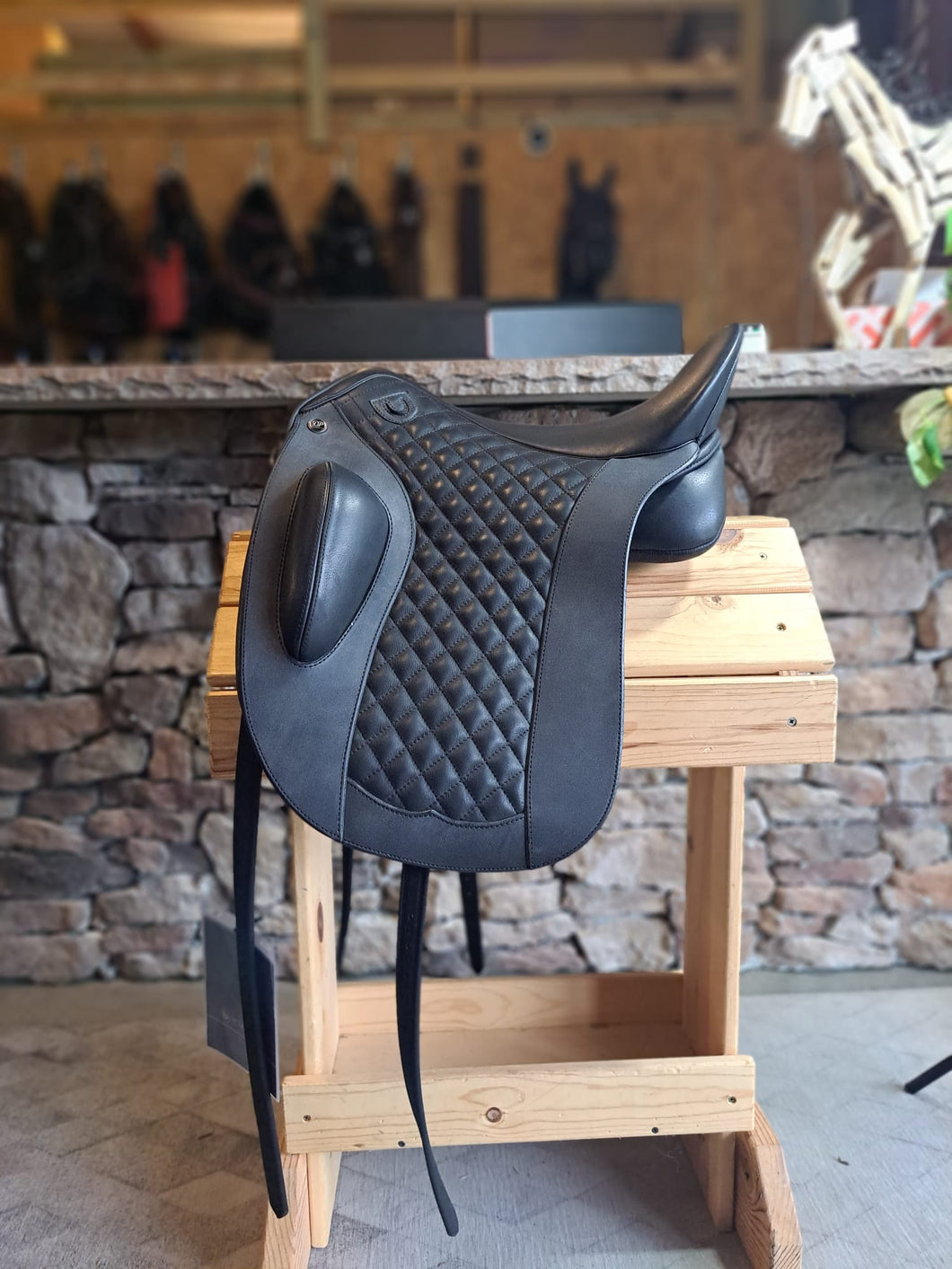 Side view of saddle on wooden saddle rack