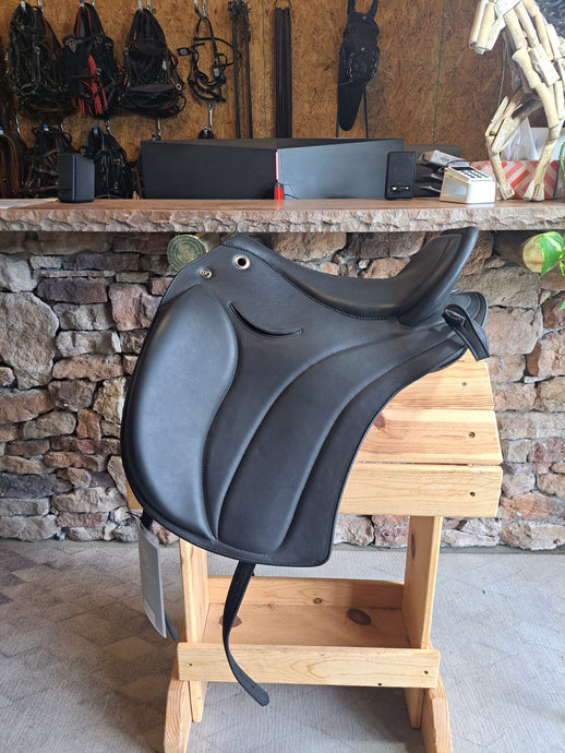 Side view of saddle on wooden saddle rack