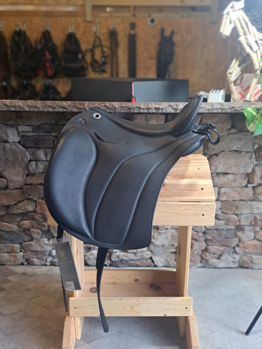 Side view of saddle on wooden saddle rack